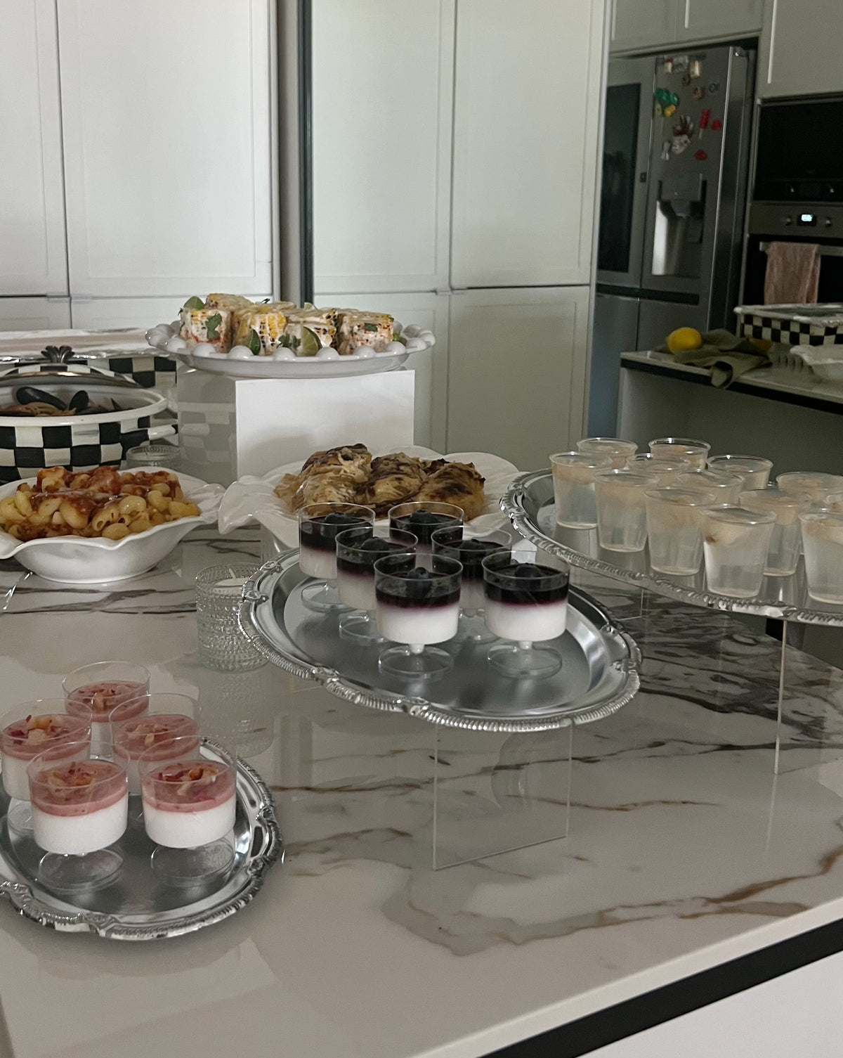 Aesthetic silver serving trays holding drinks and small desserts for a family gathering